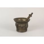 A 17th Century Spanish bronze mortar with four raised face masks intersected by buttresses,