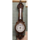 A carved oak aneroid barometer