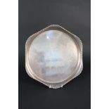 A silver circular tray with hexagonal gallery,