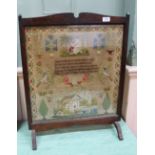 An oak fire screen containing woolwork motto, house and bird sampler by Martha Whiting, aged 12,