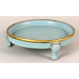 A Chinese circular blue glazed three legged plate with metal rim,