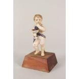 A 19th Century continental porcelain putto holding a bowl of grapes,