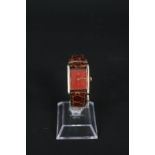 A lady's silver gilt Must de Cartier tank wristwatch with red dial on leather strap