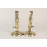 A pair of early 18th Century seamed side ejector brass candlesticks (on as found circular bases),