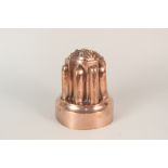 A tall Victorian copper jelly mould with eight turrets,