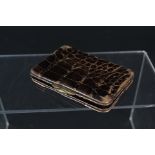 A crocodile skin purse with applied 9ct gold corners