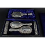A boxed silver mounted dressing table set consisting of mirror and four brushes (as found)