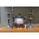 A silver plated pump action self pouring teapot and a pair of candlesticks