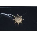 A 14ct gold star burst design pendant/broach set with seed pearls