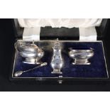 A silver three piece cruet set in original box (one non-matching silver spoon and one spoon