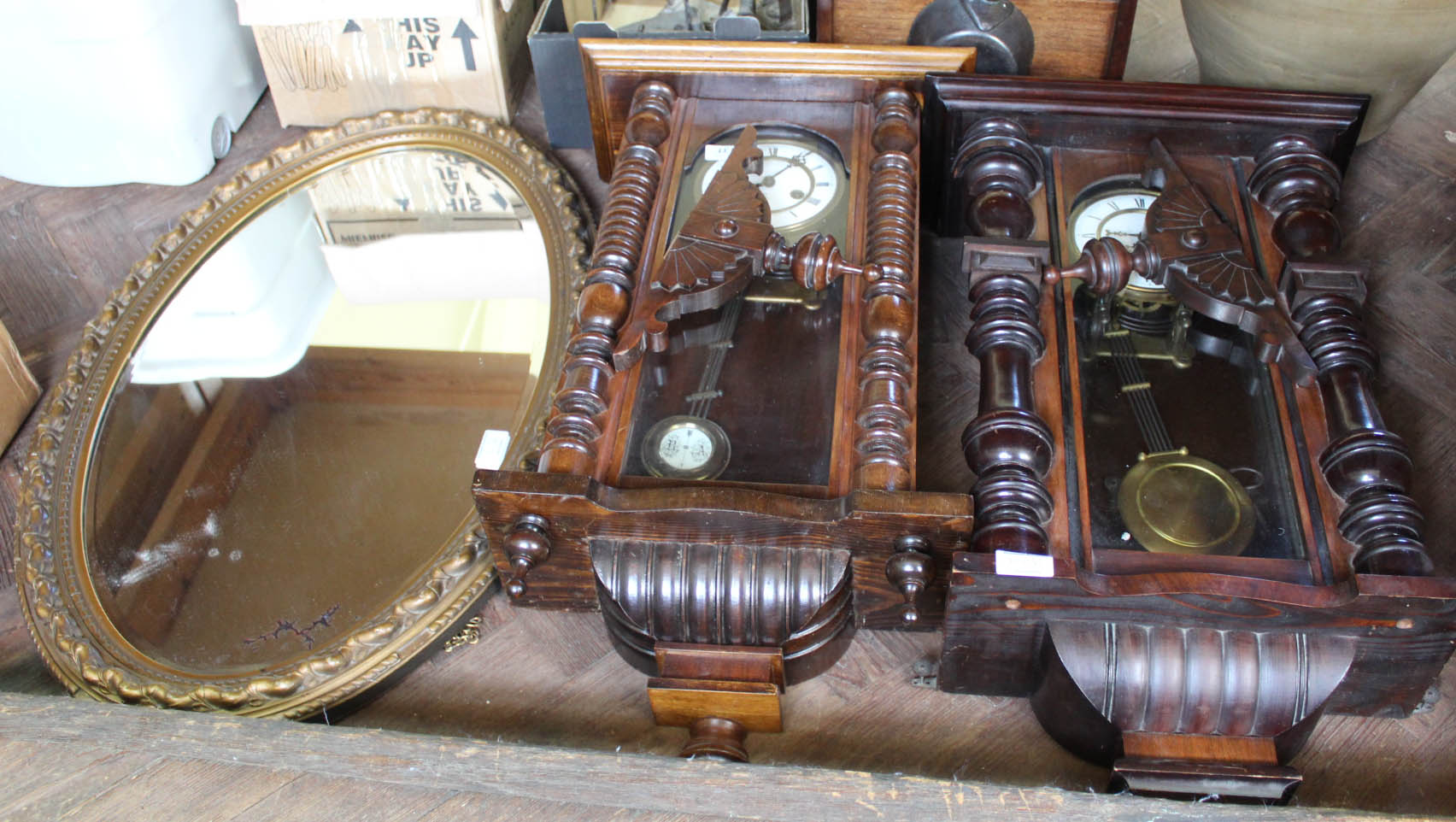 Two mahogany Vienna wall clocks plus an oval gilt wall mirror