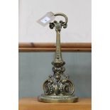 A 19th Century decoratively cast and weighted brass door stop with loop handle,