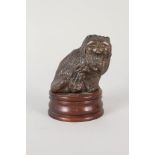 A bronze seated cat on wooden base,
