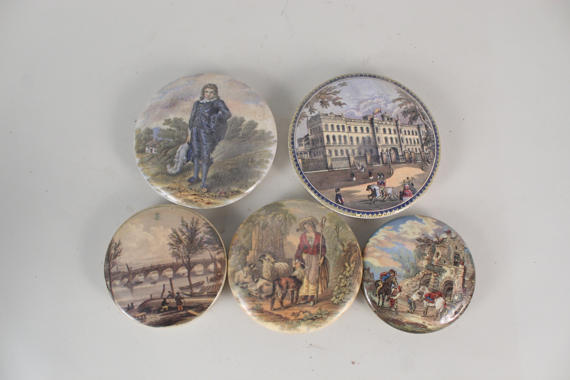 Four unframed Victorian pot lids, The Blue Boy, Bridge and Figures, Ruins with Horsemen,