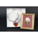 A large silver necklace set with amber together with a small oval miniature oil landscape