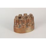 A Victorian oval copper jelly mould of fluted turret form and stamped '49',