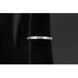 A white metal eternity ring set with baguette cut diamonds,