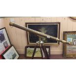 A brass telescope on wood and brass tripod