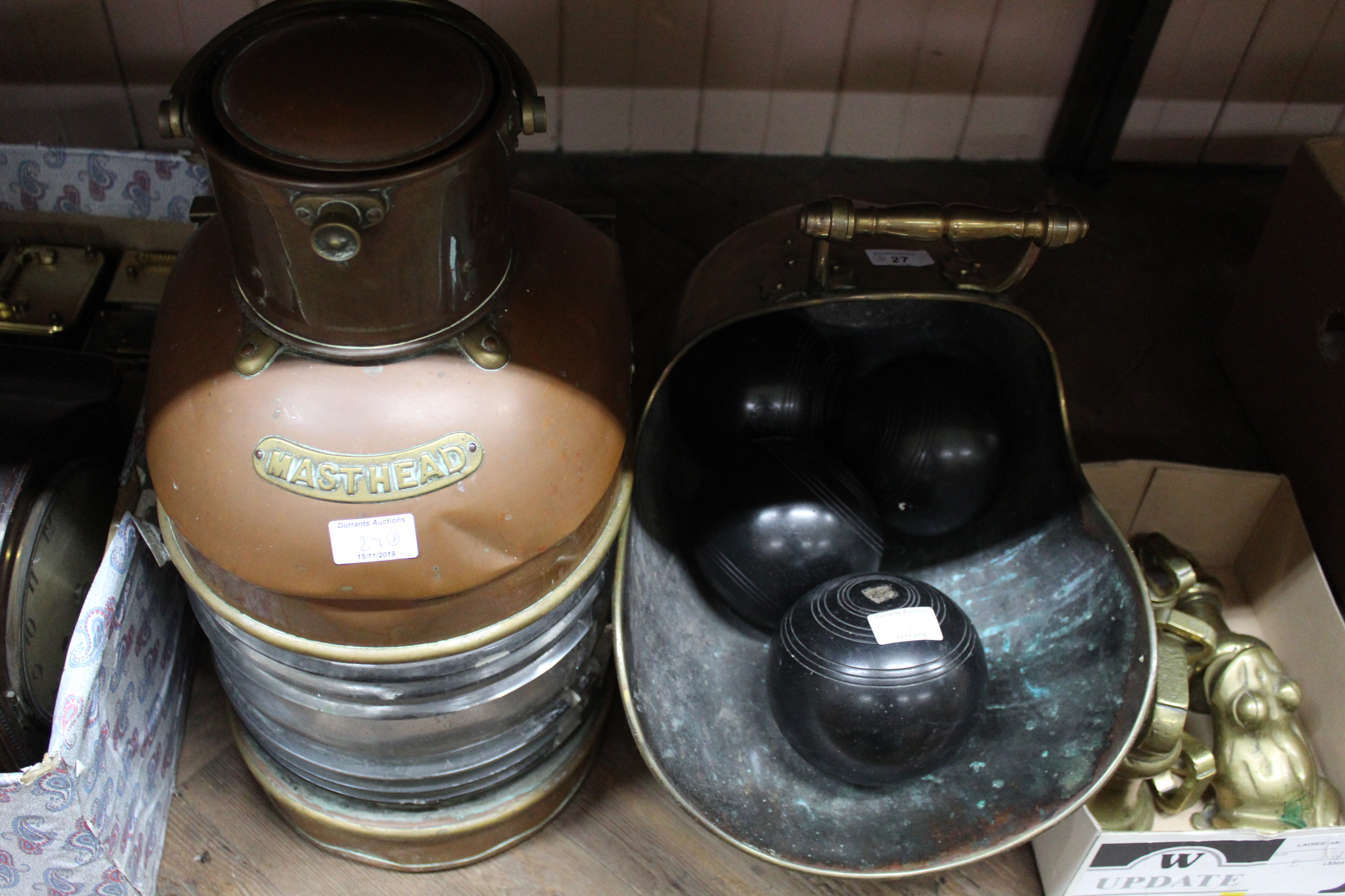 A 19th Century brass coal helmet containing four lawn bowls plus a copper ships masthead lamp