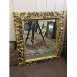 A carved gilt wood leaf motif wall mirror,