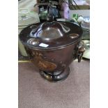 An Art Nouveau circular copper coal box and cover with raised stylised flower and boss decoration,