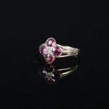 A 9ct gold ring set with four purple stones and seed pearl in a floral shape, Chester hallmark,