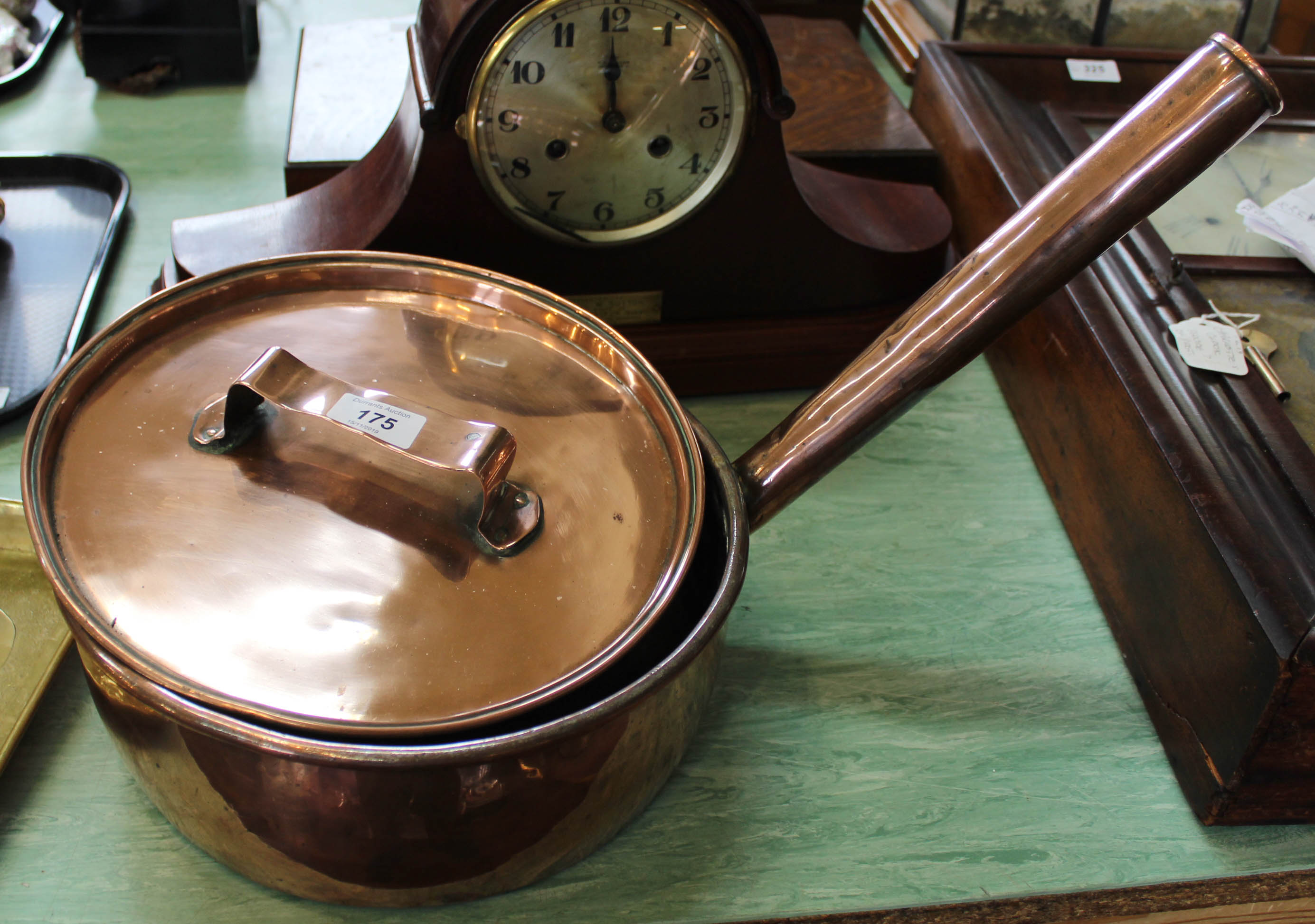 A large 19th Century seamed copper cooking pan and lid with tubular handle,