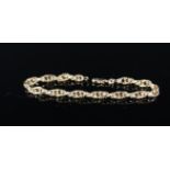 A 9ct gold ornate double loop bracelet with engraved details