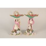 A pair of continental porcelain Rococo and floral stands with figure, sheep and goat mounts,