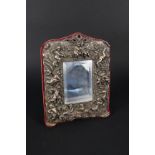 A sterling silver fronted mirror decorated with cherubs and flora,