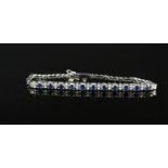 A white metal bracelet set with sapphires and diamonds