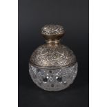 A cut glass silver mounted globular scent bottle with pierced and embossed floral decoration,
