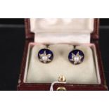 A pair of yellow metal earrings decorated with blue enamel background cut star middle with pearl