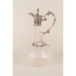 A cut glass claret jug with silver plated handle and mounts