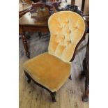 A Victorian carved mahogany button back nursing chair with mustard velvet upholstery