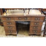 A Georgian style mahogany pedestal desk with faded red leather inset top