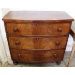A mid Victorian bow front chest of three long drawers on turned feet