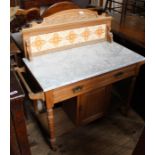 An Edwardian ash and marble top washstand with tiled upstand