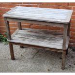 A pair of weathered teak garden tables