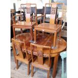 A modern Chinese hardwood extending dining table and six chairs including two carvers