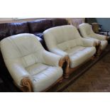 A cream leather and wooden frame Italian style three piece suite comprising a two seater sofa and