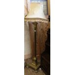An early 20th Century brass standard lamp with Corinthian column on ball and claw feet