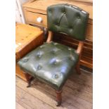 An Edwardian oak frame lounge chair with green leather button back upholstery