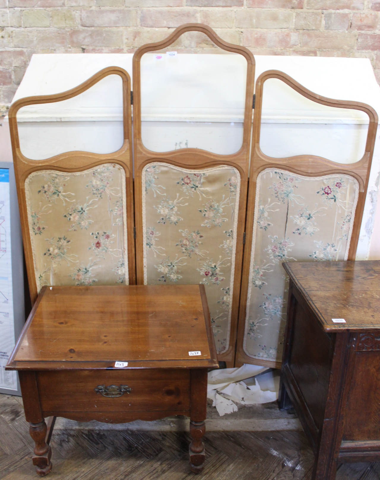 A three fold screen with mahogany frame with floral fabric and part glazed panels