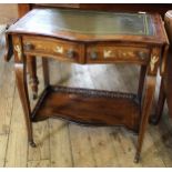 An Edwardian leather top two tier, flap leaf writing table with two drawers,