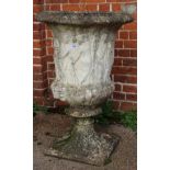 A large weathered urn on square base with Grecian figure decoration