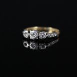 An 18ct gold and platinum illusion set three stone diamond ring,