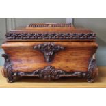 A carved wooden jewellery casket with maroon velvet interior,