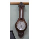A carved oak aneroid barometer