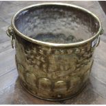 An Arts and Crafts embossed brass jardiniere or log bucket with gadrooning and lion mask ring